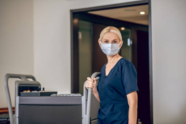 istock Service woman in a protective mask with a trolley 1327310054