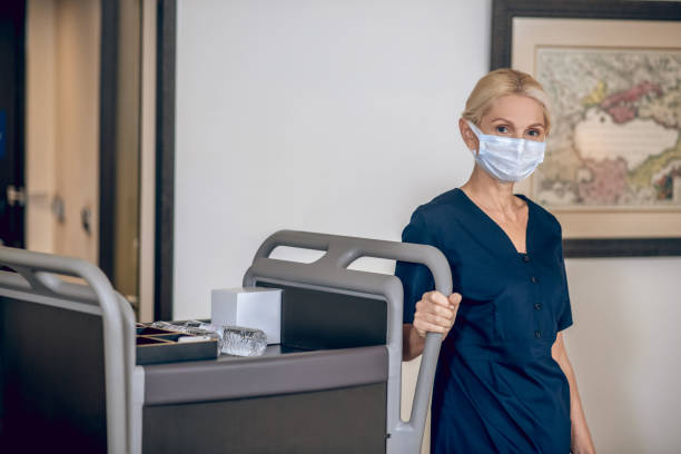 istock Service woman in a protective mask sholding bottles with water 1327310068
