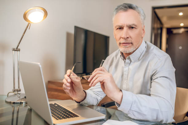 istock Gray-haired man working from home and looking busy 1327310191