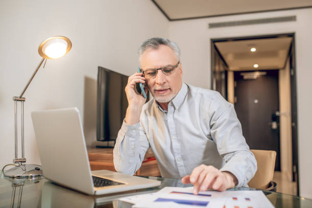 istock Mature man talking on the phone and looking involved 1327310196