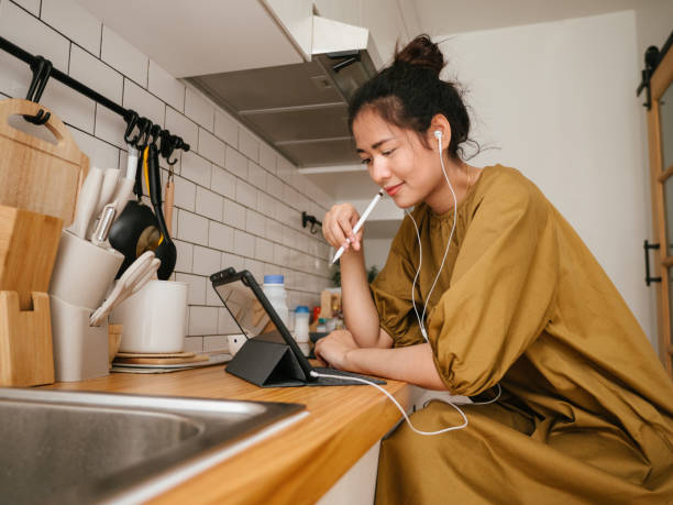 Asian women freelance working in kitchen room. Asian women freelance  working with colleague at kitchen room, quarantine and remote control  concept. lifehack stock pictures, royalty-free photos & images