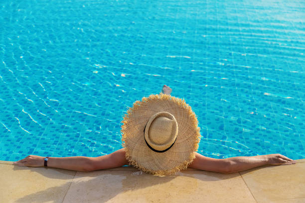 istock Woman with hat in the pool. Selective focus. 1327319479