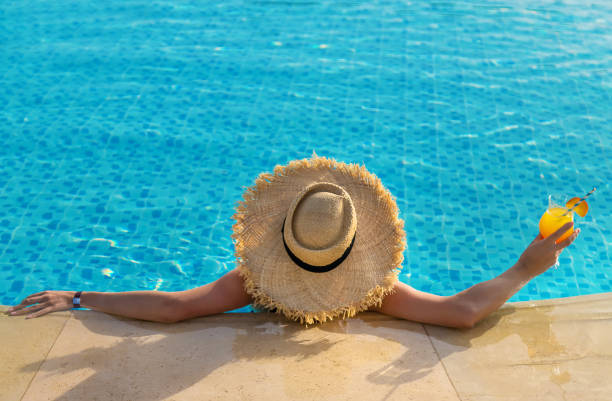 istock Woman with cocktail in the pool. Selective focus. 1327319511