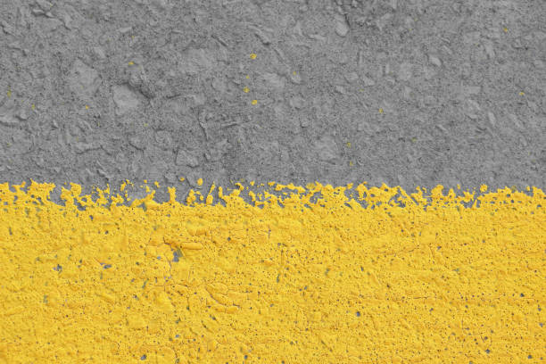 Old yellow painted gray plaster concrete wall with weatherstains, runs and defects