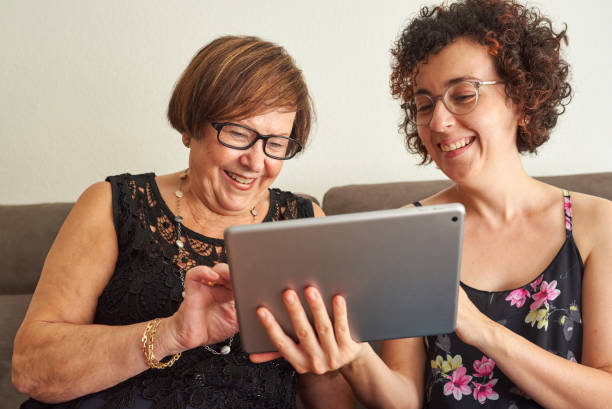 istock Daughter explains to her mother how to use the digital tablet 1327323885