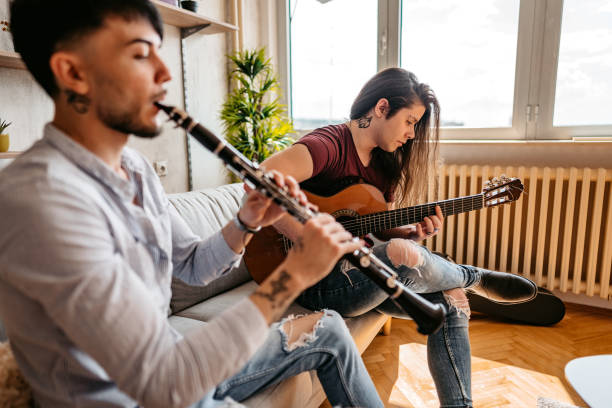 istock Two men playing clarinet and guitar at home 1327325326