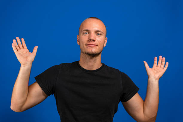 istock Young man with black shirt over isolated blue background holding copyspace imaginary on the palm to insert an ad. Gesture concept 1327325400