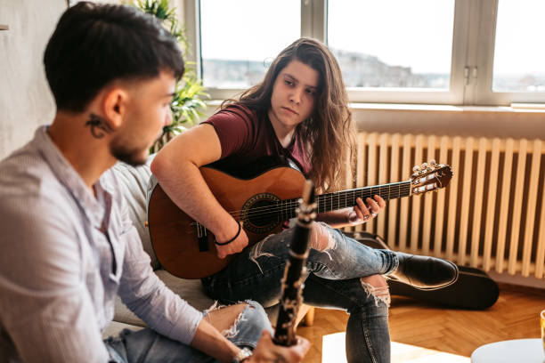 istock Two men playing clarinet and guitar at home 1327325453