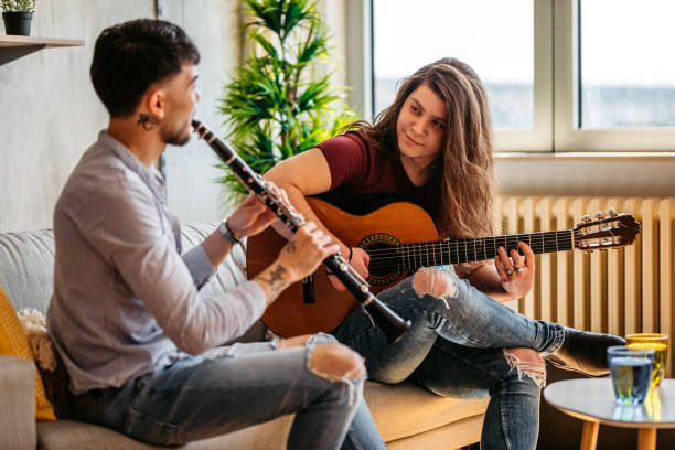 istock Two men playing clarinet and guitar at home 1327325659