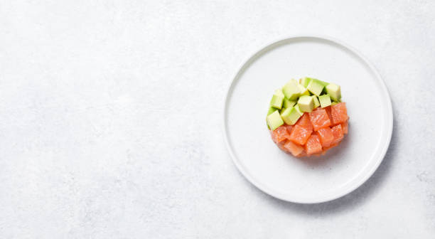 istock Salmon avocado tartare on white stone table background. 1327326834