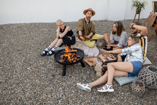 istock Friends sitting by the fireplace outdoors 1327329549