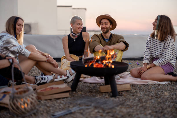istock Friends by a fireplace on the rooftop at sunset 1327329583