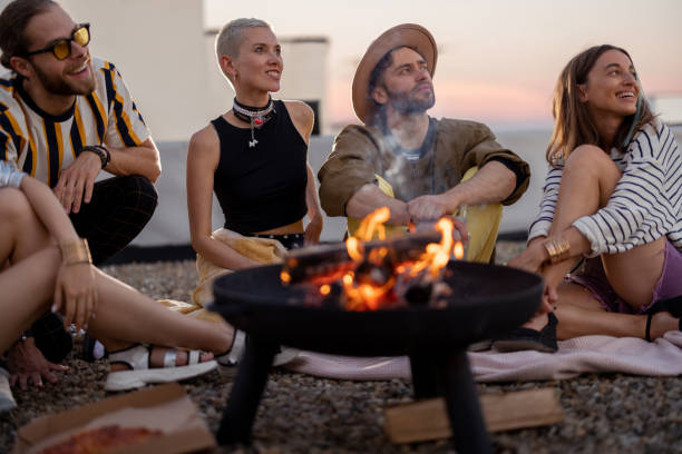 istock Friends by a fireplace on the rooftop at sunset 1327329590