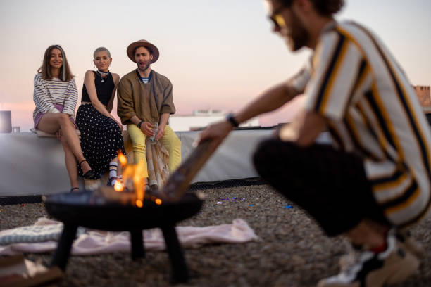 istock Friends by a fireplace on the rooftop at sunset 1327329616