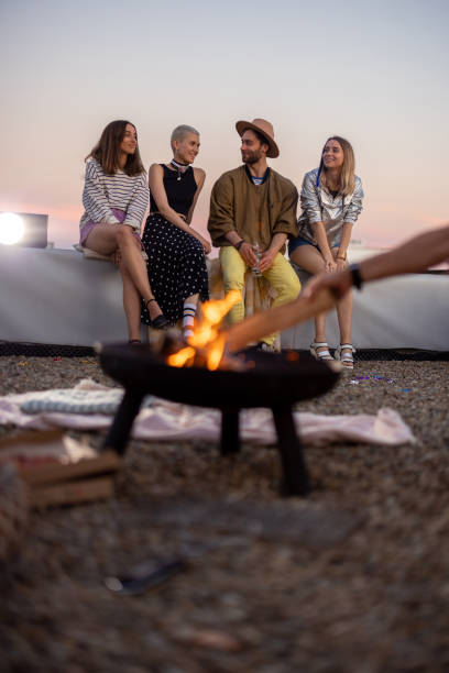 istock Friends by a fireplace on the rooftop at sunset 1327329629