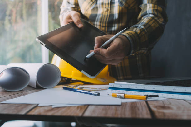 istock engineer working at a drawings of house in office for discussing. Engineering tools and construction concept. 1327331456