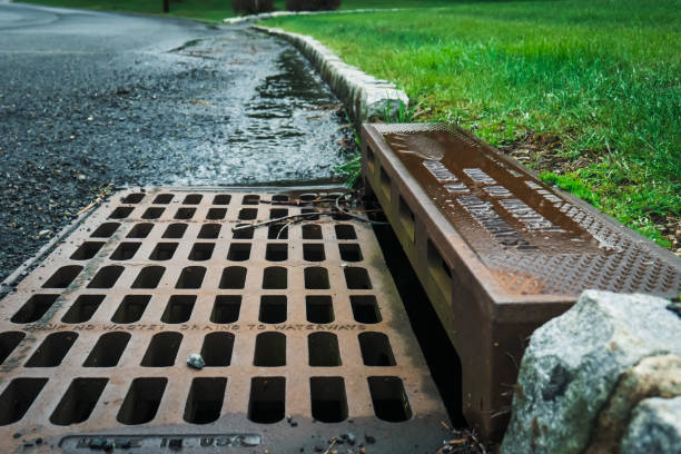 Old Storm Drain A storm drain on the side of a road reads "Dump no waste! Drains to waterways". drain photos stock pictures, royalty-free photos & images