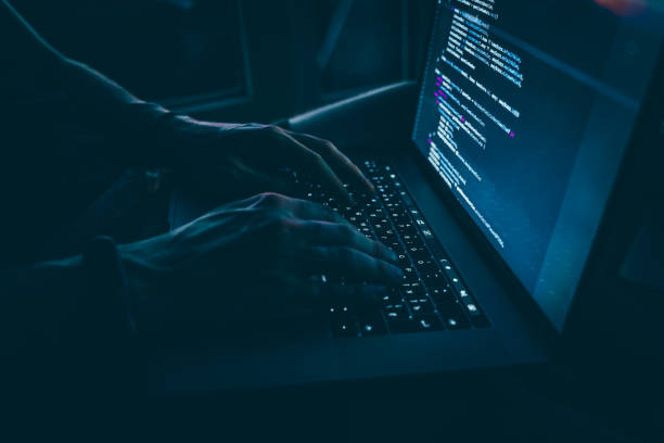 istock Programmer's hands are coding on a laptop in the dark with a view of the lights of the night city. The concept of a developer or hacker 1327335653