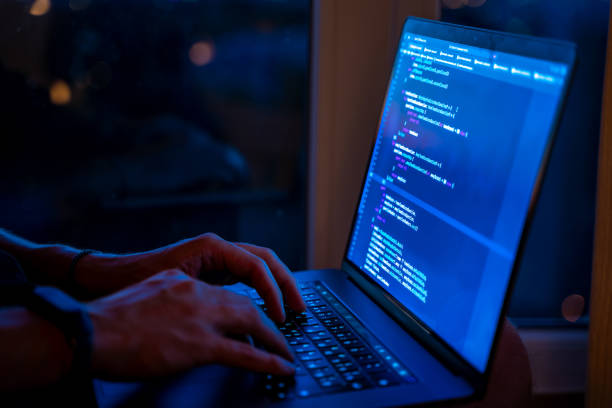 istock Programmer's hands are coding on a laptop in the dark with a view of the lights of the night city. The concept of a developer or hacker 1327335685