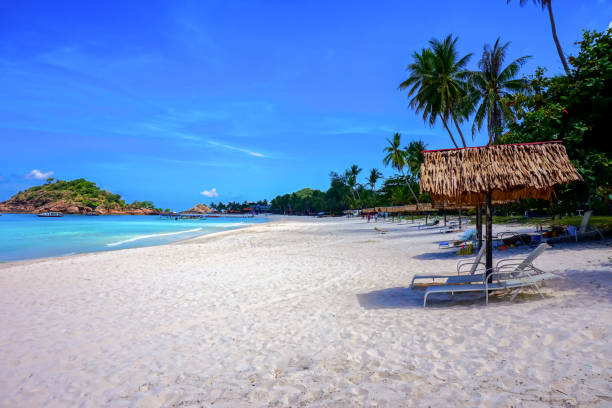 istock Beach chair with umbrella with blue sky on tropical beach 1327339395