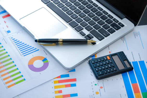 istock Laptop and pen with business charts, graphs, statistic and documents background for business and finance concepts 1327339471
