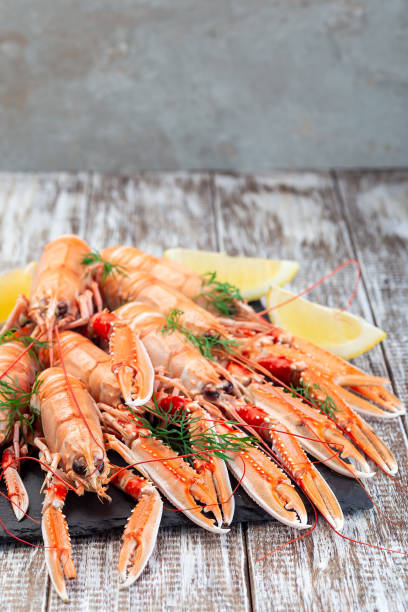 istock Sea crayfishes on stone plate served with dill and lemon, vertical, copy space 1327342690