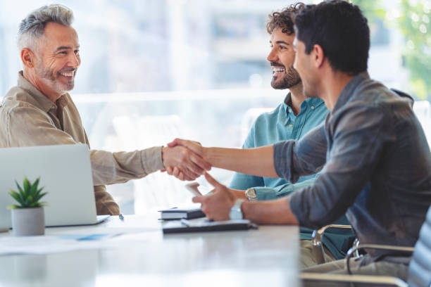 istock Three businessmen meeting, two are shaking hands. 1327351692
