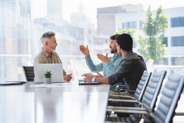 Three businessmen meeting at a board room table.