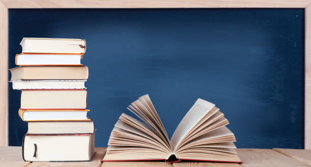 istock Open book with stack of books on the wood table 1327352994