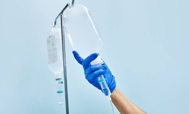 mano de la enfermera preparando un goteo intravenoso - suero fotografías e imágenes de stock