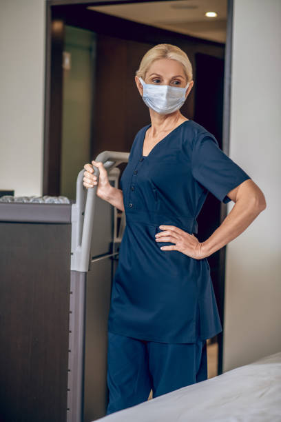 istock Service woman in a protective mask with a trolley 1327358288