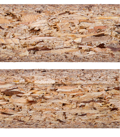 Chipboard texture in cross section. Visible chip layers in the pressed board. Isolated background.