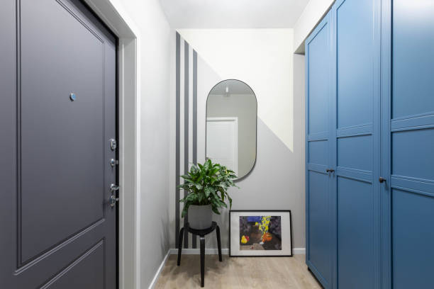 Entrance hallway in a modern design apartment: grey and white walls, built-in wardrobe. Safety home, high-quality front door Entrance hallway in a modern design apartment: grey and white walls, built-in wardrobe. Safety home, high-quality front door blue front door stock pictures, royalty-free photos & images