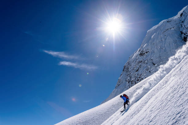 istock Backcountry snowboarder descends snowy mountain ridge 1327365446