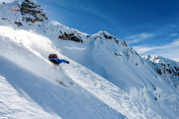 istock Backcountry snowboarder descends snowy mountain ridge 1327366029