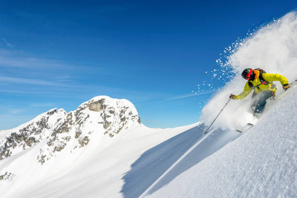 istock Backcountry skier descends snowy mountain ridge 1327366079