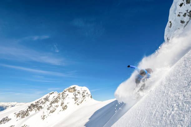 istock Backcountry snowboarder descends snowy mountain ridge 1327366121