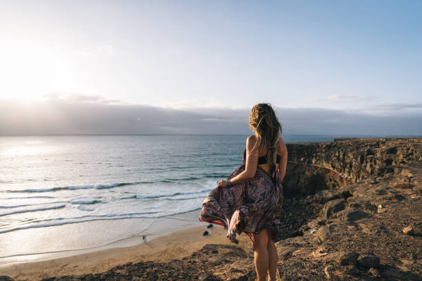 istock Young woman relaxes on coastal cliffs at sunrise 1327367199