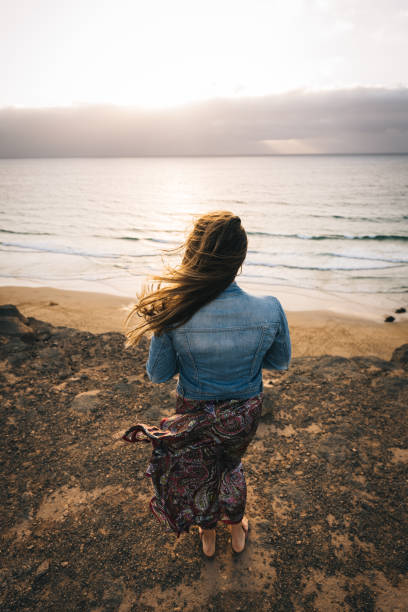 istock Young woman relaxes on coastal cliffs at sunrise 1327368043