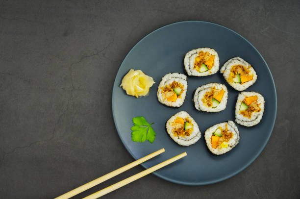 close up of delicious japanese sushi in a blue plate in a black background and a pair of chopsticks, top view - blue plate fotos imagens e fotografias de stock