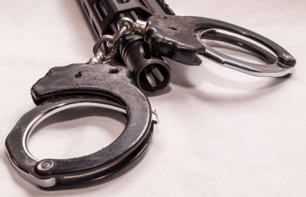 istock A rifle and handcuffs with a white background 1327376840