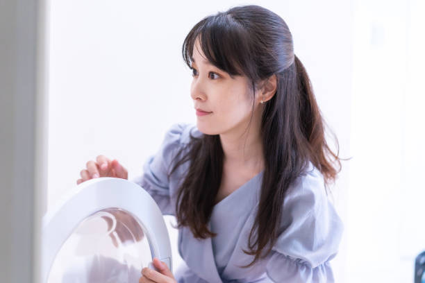 istock Young woman doing laundry at home 1327376859