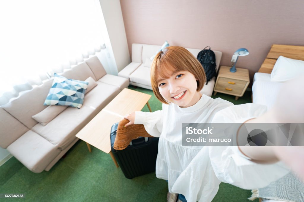 A woman taking a selfie in a hotel room Asian young woman taking a selfie in a hotel room Women Stock Photo