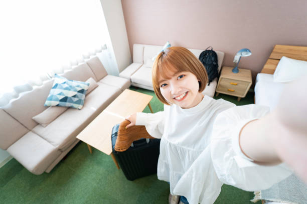 A woman taking a selfie in a hotel room Asian young woman taking a selfie in a hotel room photographing herself stock pictures, royalty-free photos & images