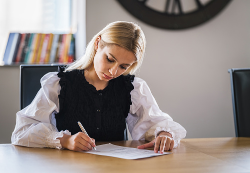 Businesswoman Signing Legal Paper In Office