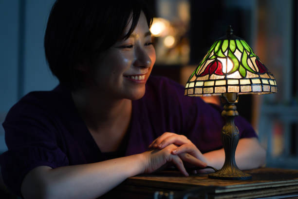 Woman turning on a stained glass lamp