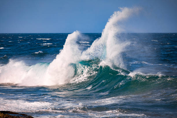 istock Deep blue ocean waves colliding along rocky coastline 1327385757
