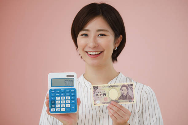 電卓と5000円紙幣を持つ女性 - 5000円 払う ストックフォトと画像