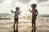 istock Portrait Of Little Children Playing And Having Fun On The Beach 1327401020