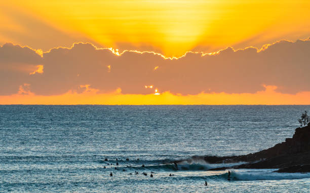 istock Surfers ride waves at sunrise 1327406603